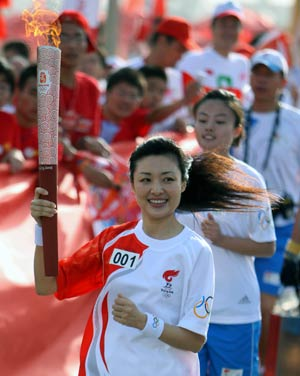Photo: Torchbearer Zhou Tao runs with the torch in Huainan