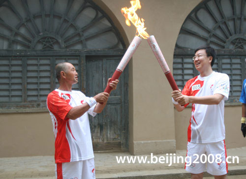 Photo: Torchbearers pass on Olympic torch