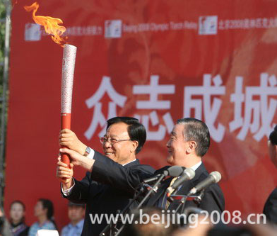 A local official receives the torch from Lu Mingde in Lanzhou, Gansu Province, on July 7, 2008.