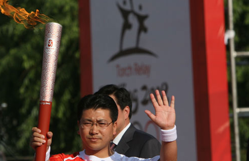 First torchbearer Tian Yu holds up the torch in Lanzhou, Gansu Province, on July 7, 2008.