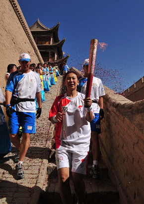 Torchbearer Yang Yang carries the torch during the 2008 Beijing Olympic Games torch relay in Jia Yuguan, a city in northwest China's Gansu Province, on July 6, 2008.
