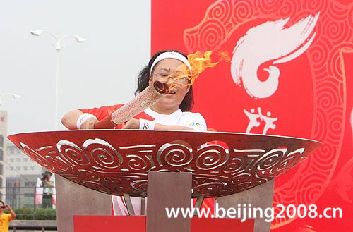 Last torchbearer Siqingaowa lights the cauldron during the torch relay in Chifeng city, Inner Mongolia Autonomous Region, on July 10, 2008.