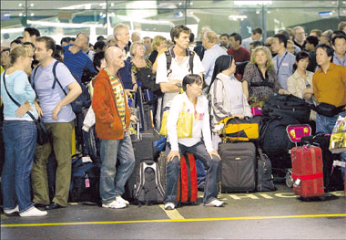Frustrated tourists wait for transport yesterday at Thailand's main airport in Bangkok. Thousands of travelers were stranded, including about 400 from Shanghai, on Tuesday night when anti-government protesters swarmed the terminal, causing the airport to shut down. The protesters tightened their grip yesterday, triggering speculation of military intervention. 