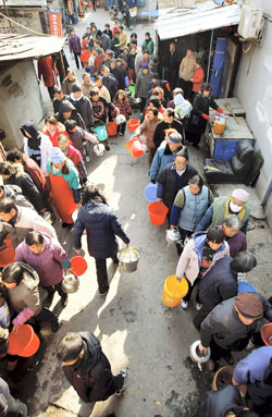 Bucket-toting residents in Shanghai's Songjiang District were lining up in front of fire bureau pumper trucks yesterday as a leak and equipment failures cut the water supply to 350,000 families in the district's central area.