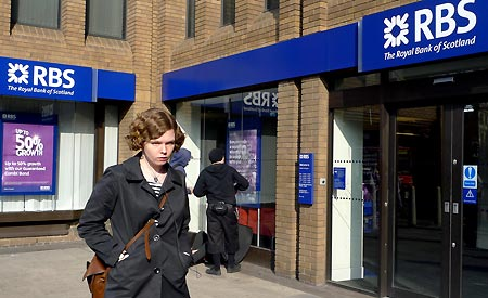 File photo taken on March 21, 2009 shows a woman walking past a branch of the Royal Bank of Scotland (RBS) in London, Britain. RBS said on April 7 that it might cut up to 9,000 jobs over the next two years, including 4,500 in the UK, in order to reduce cost. [Xinhua]