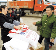 Residents in Mianzhu, one of the worstdamaged areas in quake-hit Sichuan Province, receive daily necessities from local authorities. Nearly one year after the devastating May 12 earthquake that left more than 80,000 dead or missing, survivors are waiting in hope for a better future. 