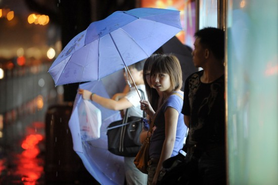 People take a shelter from the rain in a bus station in Shenzhen on June 26. Nangka, the fourth tropical storm this year, made its second landfall in south China's Guangdong Province early Saturday morning, before weakening to depression. [Xinhua]