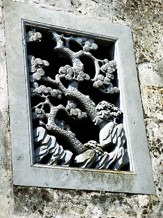 A graceful stone-carved window in the West Garden in Xidi Village.