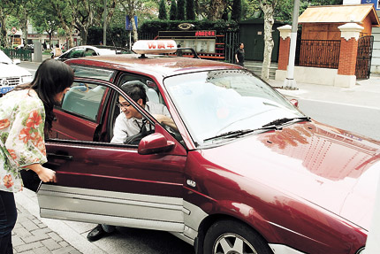 A woman rushes to a taxi, waiting for a passenger, during the morning rush hours. People often complain being unable to find a cab during rush hours.