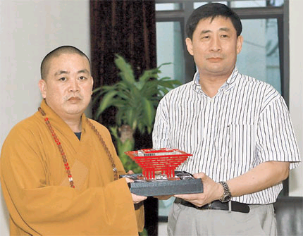 Shi Yongxin, the 30th abbot of Shaolin Temple, receives a model of the China Pavilion as a gift from Hong Hao, director of the Bureau of Shanghai World Expo Coordination, yesterday.