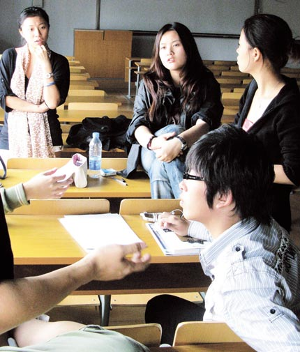 The organizers, a group of eight third-year students at the Sino-British College, brainstorm the Winter Warmer Festival. The event combines live music with 10 vendors selling handicrafted items such as necklaces.