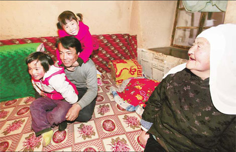 Yang Guoxing, his two daughters and his mother in their cave house at the foot of a tower of the ancient Xiamaguan city wall, which is part of the Great Wall.