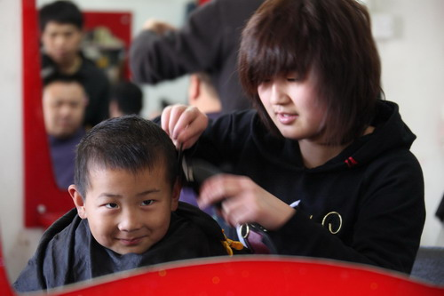 A child gets a haircut at a barbershop in Hefei, Anhui province March 17, 2010. It is believed to bring luck when one gets a haircut during the second day of the second Chinese lunar month, which falls on March 17 this year.