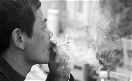 A man smokes in his office in Guangzhou, capital of Guangdong province, on Wednesday.
