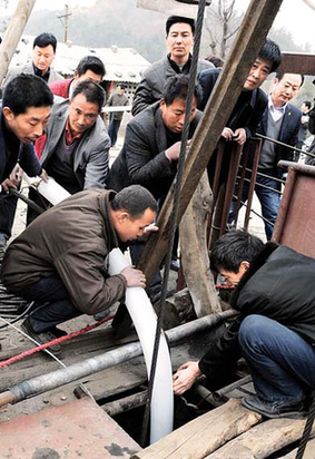 Rescuers insert a tube into a flooded coal mine to pump out water in Biyang county, Henan province, on Monday.  