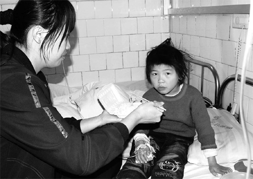 A woman feeds hier child, who was disgnosed with lead poisoning in Chenzhou Hospital of Chinese Medicine on Tuesday. 