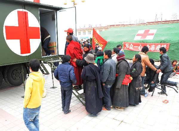 People wait to receive treatment at a military tent hospital in Gyegu Town of earthquake hit Yushu County of northwest China's Qinghai Province e,April 16,2010.Dozens of medical team have rushed to Yushu from all over China since the 7.1-magnitude quake struck here early Wednesday