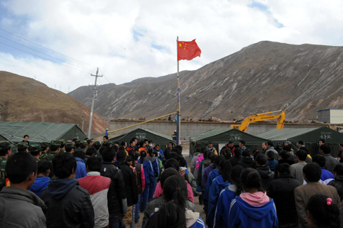 Students attend a ceremony for returning to school in front of tents used as classroom on the first school day since the April 14 earthquake in Yushu, Qinghai, April 18, 2010. 