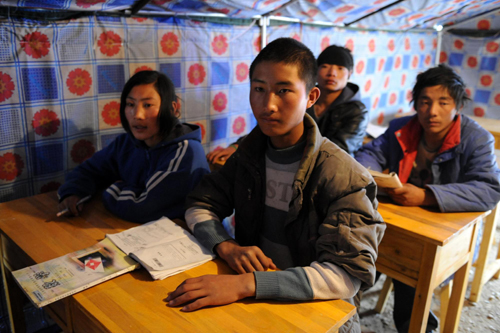 Students attend a class in a tent on the first school day since the April 14 earthquake in Yushu, Qinghai, April 18, 2010.