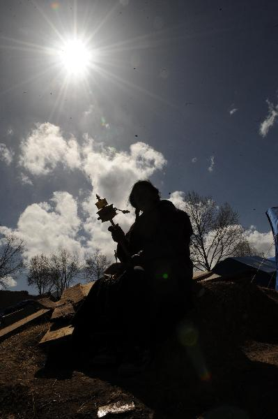 A local resident of China's Tibetan Ethnic Group turns the prayer wheel in the quake-hit Gyegu Town of Yushu County, northwest China's Qinghai Province, April 20, 2010. 