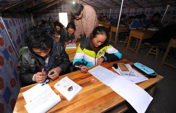 Fifteen-year-old Jiangyong (R, front) and classmates have a class in a tent in Yushu, northwest China's Qinghai Province, April 20, 2010. 
