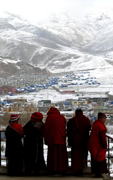 Lamas look at the tent area in the quake-hit Tibetan Autonomous Prefecture of Yushu, northwest China's Qinghai Province, April 22, 2010.(