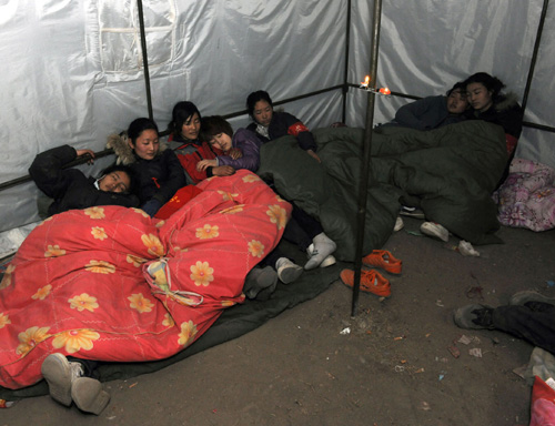 Volunteers rest in a tent in Yushu, Northwest China's Qinghai province on April 21, 2010. These volunteers, made up of 10 ethnic Tibetan young people (5 girls and 5 boys) from Qinghai and one girl from Central China's Henan province, came right after the 7.1-magnitude quake hit Yushu.