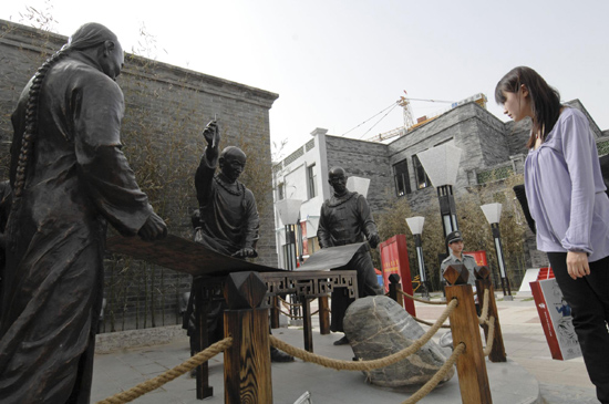 A visitor looks at statues outside of Taiwan guild house on Qianmen Street in Beijing, May 7, 2010. [Photo/Xinhua]