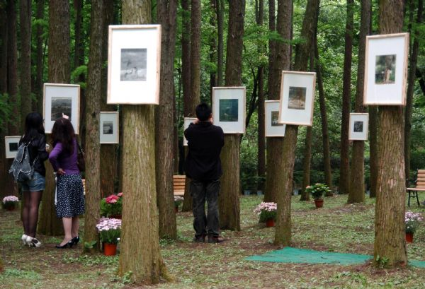 People view paintings of famous Chinese artist Zeng Mi's paintings at his personal exhibition held in the Hangzhou Botanic Garden in Hangzhou, capital of east China's Zhejiang Province, May 23, 2010. 