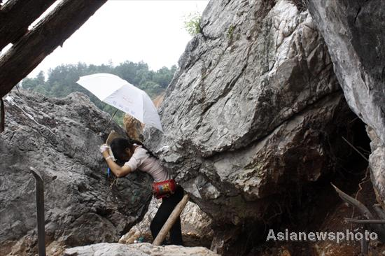 A woman is stuck between two big rocks after the collapse of a quarry in Jiujiang, South China's Jiangxi province, June 1, 2010. The 30-year-old was pulled out after two hours but died despite best efforts. The dying woman kept crying out for her baby, which greatly touched everyone present. [Photo/Asianewsphoto]