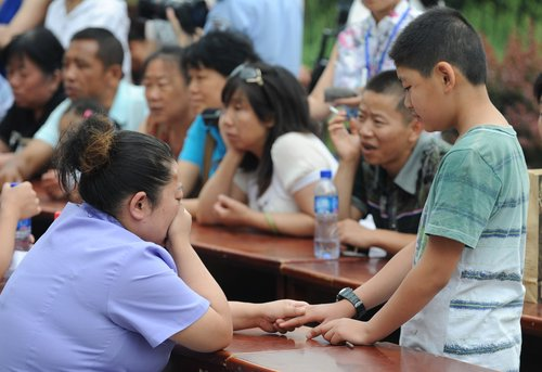 A mother cries as she meets her son during the Open House at a compulsory rehabilitation center in Taiyuan, North China's Shanxi province, June 22, 2010. Local police organized the event and invited relatives to visit drug addicts receiving treatment at the center ahead of the International Day against Drug Abuse and Illicit Trafficking on June 26.