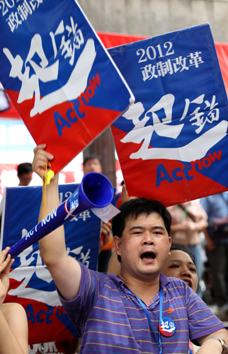 Supporters of the Hong Kong government's political reform package wave banners outside the Chamber of the Legislative Council building in Hong Kong on Wednesday, as lawmakers debate the amended political reform package for 2012.