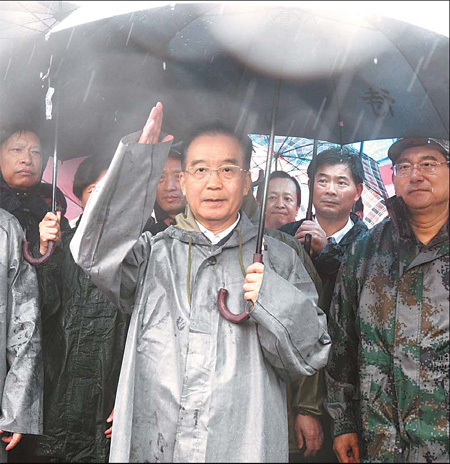 Premier Wen Jiabao speaks to People's Liberation Army soldiers and civilian rescuers fighting floods in Fuzhou, Jiangxi province, on Thursday.