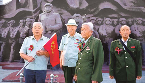 Veterans of the War to Resist US Aggression and Aid Korea stand in front of a war memorial on June 10 in Dandong, Liaoning province. They are part of a group who left for North Korea on June 11 to pay condolences to the soldiers who died there. 