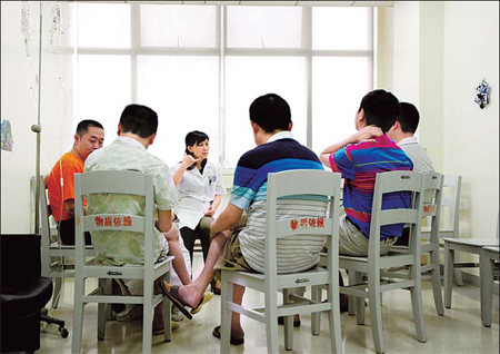 Cai Ying, center, a psychiatrist at West China Hospital in Chengdu, talks with alcoholics during a regular group therapy session as part of the hospital's Alcoholics Anonymous. The program is the first of its kind in Sichuan. 