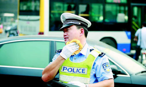 A policeman is on duty in Beijing in muggy weather. North China including Beijing and Tianjin has seen muggy weather for the past week with the minimum temperature a notch above average at 35 degrees Celsius. The meteorological observatory said rains were expected later this week. [Photo from Qianlong.com]