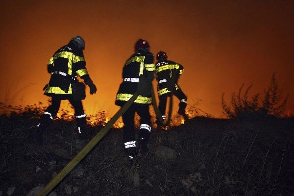 Firefighters attempt to extinguish a fire burning in the scrubland and pine forests between Arras and Teyran near Montpellier, in Herault region, southern France, August 31, 2010.