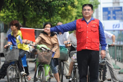 Billionaire Chen Guangbiao, chairman of Jiangsu Huangpu Renewable Resources Utilization Co Ltd, volunteers as a traffic warden on Sept 7 at a road crossing in downtown Nanjing, capital of Jiangsu province.