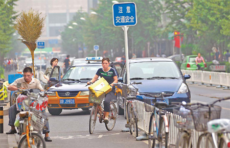 A taxi driver blocks a bicycle lane with his cab to pick up a passenger in downtown Beijing. Cyclists say it is a common sight and complain inconsiderate drivers and the increase in faster electric bikes have made the streets a more dangerous place to ride. 