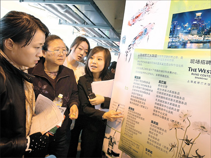  Fresh university graduates check job information during a job fair in Shanghai. Nowadays more and more post-1990s generation is turning to digital means to look for jobs.