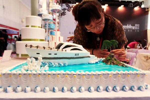 A staff member at a bakery works on a yacht cake at an exhibition in Beijing on Sept 10. Cakes are one of the foods that contain trans fat, which poses threats to health.