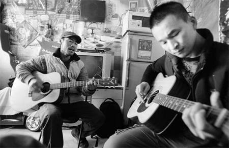 Migrant workers Wang Xu (left) from Henan province and Liu Gang from Heilongjiang province sing In the Spring in a 6-square-meter rented room in the suburbs of Beijing on Oct 28. 