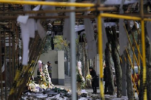 Mourners lay flowers at the entrance of the gutted apartment block on Wednesday.