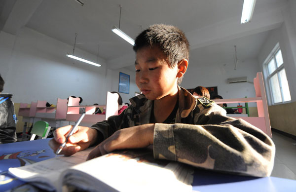 Children attend a class at a school for orphans whose parents died of AIDS in Shangcai county, Henan province on Nov 30, 2010. [Photo/Xinhua] 