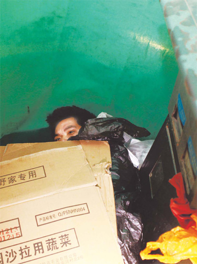 A 23-year-old man from Shandong province who has been sleeping in a disused telephone booth at Beijing Railway Station for about a month. He sleeps most of the day, rising only to search for food. Like many other homeless people, he rejected an offer of help from a State-run social assistance center. 
