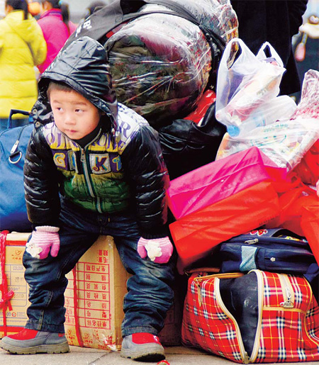 Railroads, take me home A young passenger waits for a train at Guiyang railway station in Guizhou province on Monday as people flocked to the station after sleet forced the closure of the province's highways.