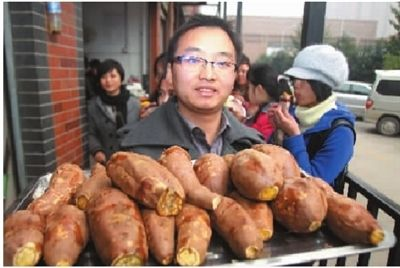 Li Kengqiang, boss of 'Dr. Sweet Potato' sells grilled sweet potato at campus in Changsha, capital of Central China's Hunan province, Jan 4, 2011.