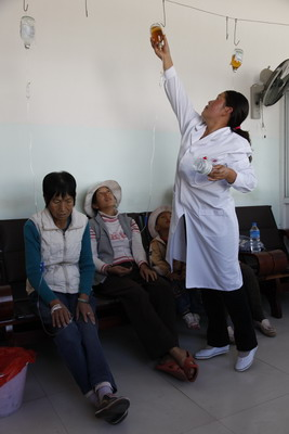 Doctor Li Yuping puts up a drip for a patient in Zhanggang village, Midu county, Dali prefecture.
