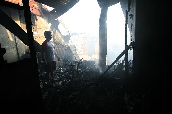 A resident looks at their burnt down home in Quezon City, north of Manila, the Philippines, Feb. 8, 2011. Some 5,000 families were left homeless and investigators are still looking into what caused the fire.