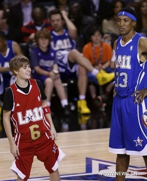 American young singer Justin Bieber (L) and former NBA player Scottie Pippen react during the 2011 BBVA All-Star Celebrity basketball game as a part of the NBA All-Star basketball weekend in Los Angeles, the United States, Feb. 18, 2011.